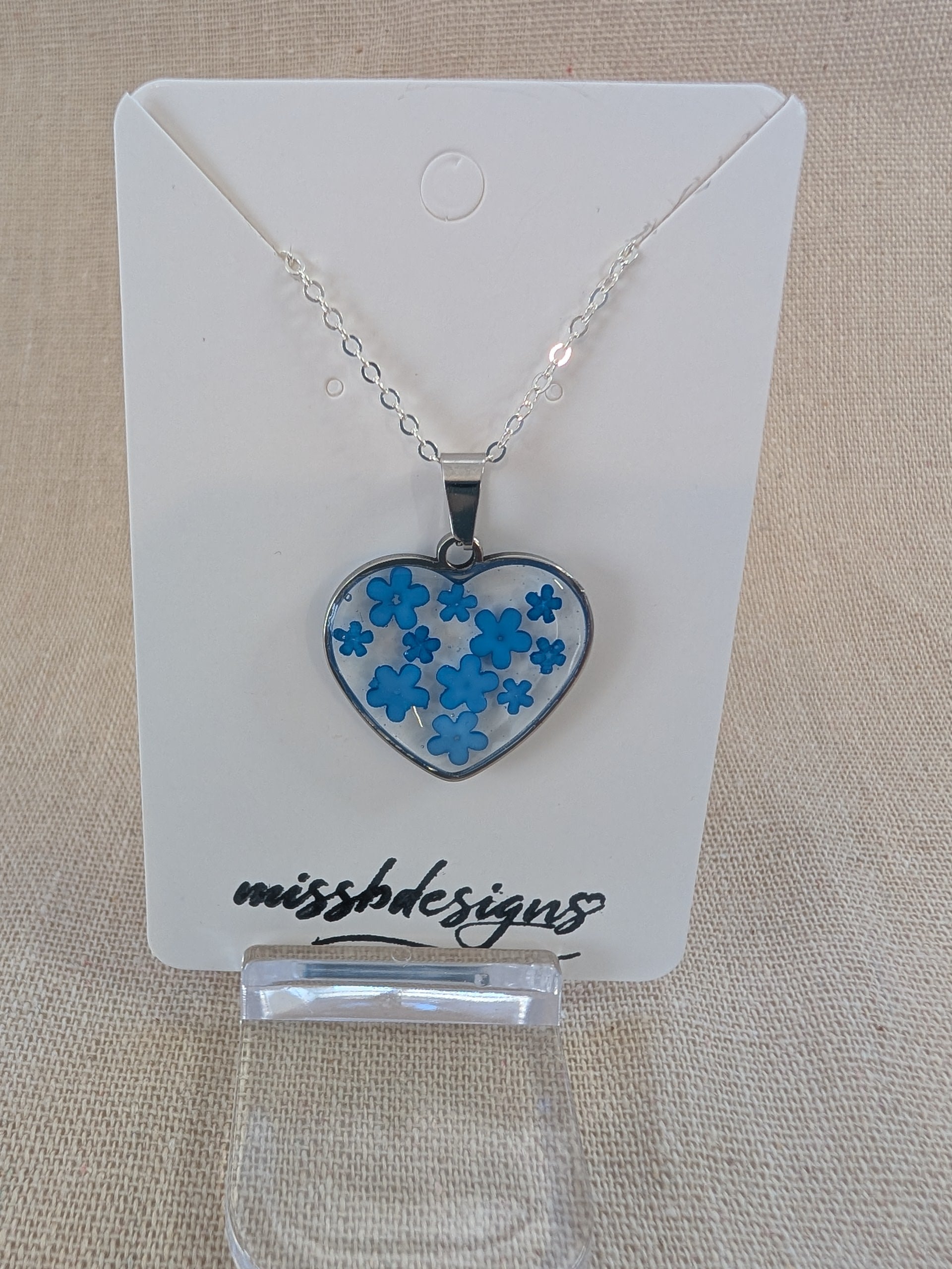 Heart shaped drop pendant with blue flowers set in resin on silver chain perfect handcrafted gift