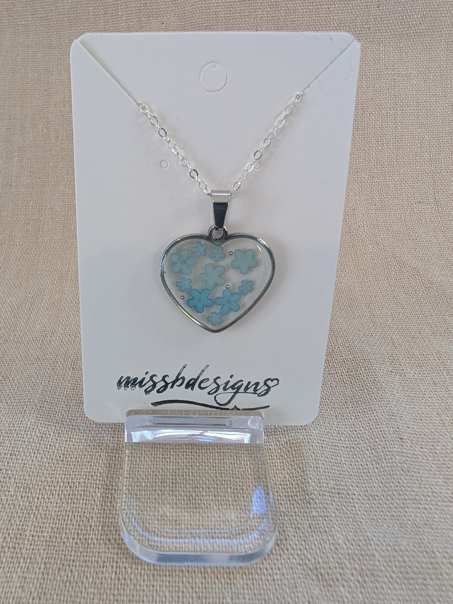 Heart shaped drop pendant with blue flowers set in resin on silver chain perfect handcrafted gift